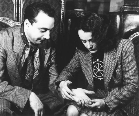 Edith Piaf reading the palms of Django Reinhardt c. 1940. Photo by Gilles Petard/Redferns.